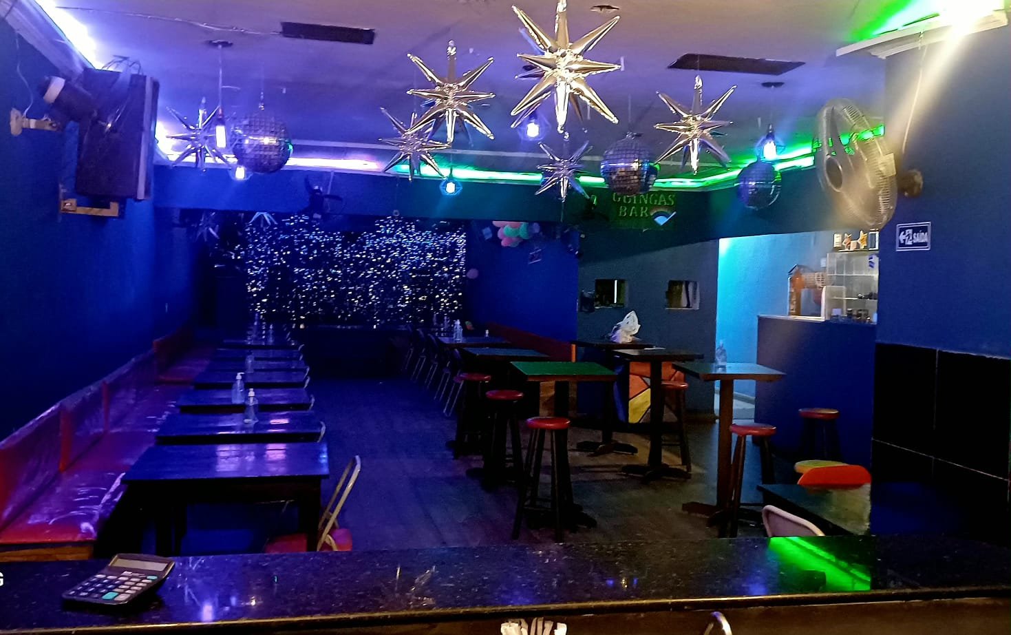 Salão decorado do Guinga's Bar com letreiro neon